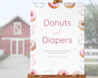 May include: A white sign with pink and white donuts and diapers printed on it. The sign reads "Donuts and Diapers" with the text "Welcome at our baby shower honoring mum-to-be Betty Love" below.