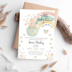 Puede incluir: Una invitación a una fiesta de bienvenida al bebé con un arcoíris de acuarela y una olla de oro. El texto dice "un pequeño amuleto de la suerte está en camino". La invitación es para Lauren Darling el lunes 7 de marzo a las 6 PM. RSVP a Lucy al (123) 456-7890. Registrado en BabyBaby.