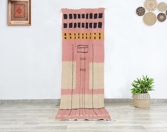 Moroccan wool runner rug in blush pink with abstract tribal motifs, hand knotted Berber hallway rug for boho modern decor