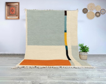 Auténtica alfombra marroquí de lana, Beni Ourain, con un diseño geométrico minimalista en beige, salvia y terracota, ideal para interiores escandinavos o bohemios.