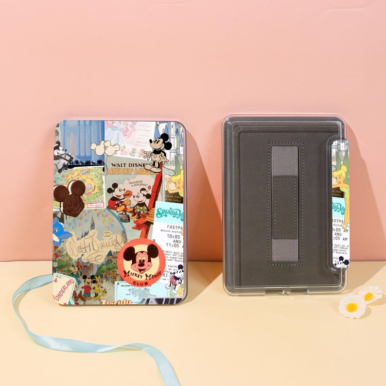 May include: A rectangular tablet case with a colorful collage design featuring Mickey Mouse and other Disney characters. The case is open, revealing a gray interior with a stand. The text "WALT DISNEY MICKEY MOUSE CLUB" is visible.