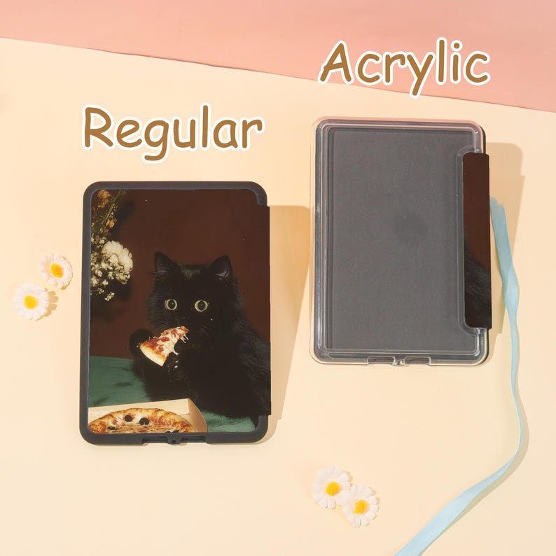 May include: A black tablet case with a cat eating pizza, labeled "Regular", next to a clear acrylic case. The cat image is on a dark background. The word "Acrylic" is above the clear case.