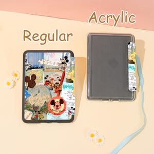 May include: A clear acrylic case with a colorful collage design featuring Mickey Mouse and other Disney characters. The case is shown next to a clear, empty case. The word "Regular" is above the case with the design, and the word "Acrylic" is above the empty case.