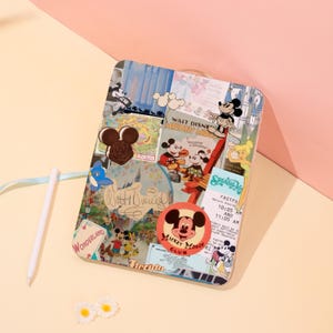 May include: A clear, rectangular case featuring a collage of Mickey Mouse imagery. The design includes vintage-style graphics, character illustrations, and the text "WALT DISNEY MICKEY MOUSE CLUB". A white stylus and two small daisy decorations are also present.