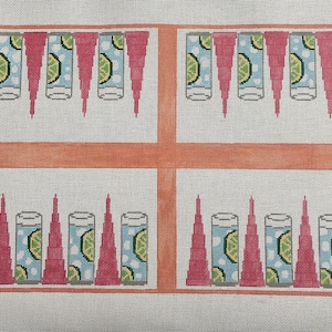May include: Needlepoint canvas featuring a grid design with four sections. Each section displays a row of cocktail glasses with lime slices, alternating with pink triangular shapes. The background is a light gray.