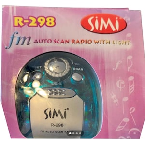 Puede incluir: Una pequeña radio FM de escaneo automático de color turquesa con luz, en una caja rosa y morada. La radio tiene una cara plateada con la marca "SIMI" y el número de modelo "R-298". La caja también muestra el texto "FM AUTO SCAN RADIO WITH LIGHT".