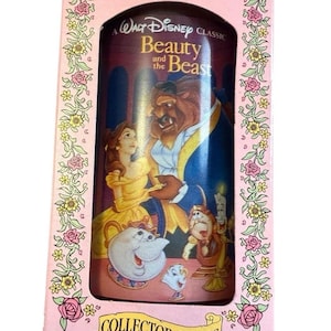 May include: A vintage "Beauty and the Beast" collector's series box. The pink box features floral and rose designs, framing the cylindrical container with the film's characters. The container displays Belle, the Beast, and other characters.