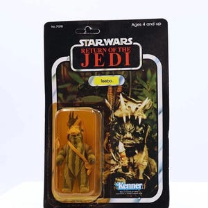 Puede incluir: Figura de acción vintage de Star Wars Return of the Jedi de Teebo, empaquetada en una tarjeta en blanco y negro. La figura está en una caja de plástico transparente. La tarjeta presenta el logotipo de Star Wars y el logotipo de Kenner.