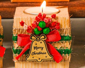 May include: Six wooden candle holders with a Christmas theme. Each holder has a different design with red and green ribbon, burlap, and a small wooden ornament. The ornaments say "Merry Christmas" and feature a reindeer, a bell, a snowflake, and a Christmas tree.