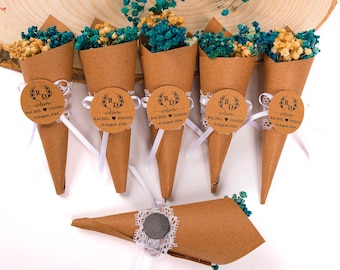 May include: Brown paper cones filled with dried flowers and tied with white ribbon. Each cone has a round label with the initials "R" and "D" and the text "welcome Rachel Daniel 10 August, 2024".