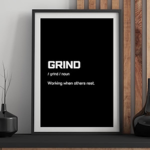 May include: A framed black and white print with the word "GRIND" in bold white letters. Below the word is the definition and the phrase "Working when others rest."