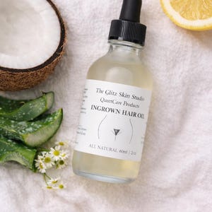 May include: A clear glass bottle of ingrown hair oil with a black dropper, labeled "The Glitz Skin Studio." The image includes a half coconut, aloe vera leaves, a lemon slice, and small white flowers. The bottle contains 2 fl oz of product.