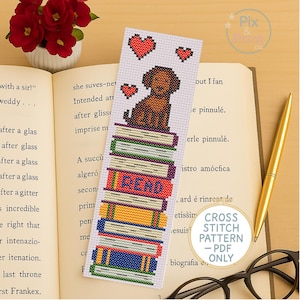 May include: A cross stitch pattern bookmark featuring a brown dog sitting on a stack of books with the word "READ" on the front book. The bookmark is white with red hearts and a white background.