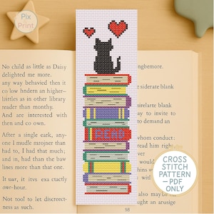 May include: Cross stitch pattern for a bookmark featuring a black cat sitting on a stack of colorful books with the word "READ" on one of the books. Two red hearts are floating above the cat. The pattern is available as a PDF download.