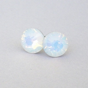 May include: A pair of small, round, white opal stud earrings. The earrings have a silver backing.