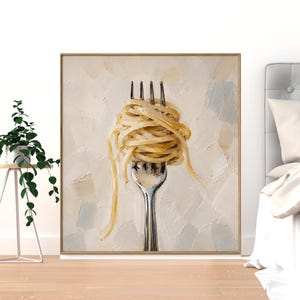 Puede incluir: Una obra de arte enmarcada que presenta un primer plano de un tenedor plateado con un remolino de espaguetis cocidos. La pasta es de color amarillo claro y el fondo tiene un efecto pintado texturizado blanco roto y gris.
