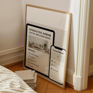 May include: A framed print with the text "INTERACTIVE AIRBNB DIGITAL WELCOME BOOK" and a smartphone displaying "House Manual". The print shows a living room scene and menu options. The smartphone displays a map.