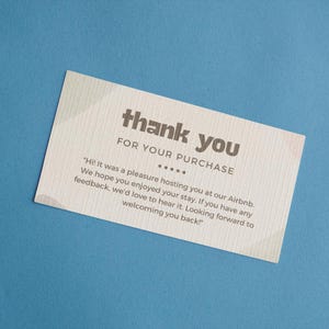 Puede incluir: Una tarjeta de agradecimiento con fondo beige y texto marrón. La tarjeta dice "gracias por su compra" e incluye un mensaje agradeciendo al cliente por su estancia en un Airbnb.