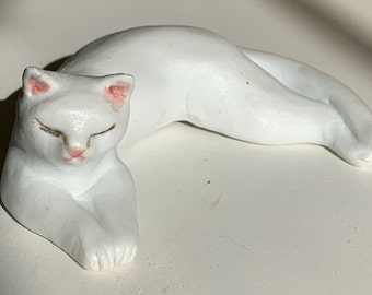 white porcelain lounging cat