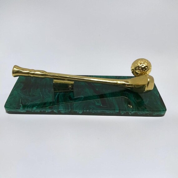 A genuine 1960s brass golf club and ball mounted on a sculpted green resin base — actual mid-century object turned into a desk sculpture, not a reproduction.