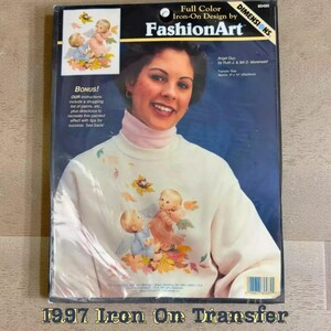 The image is a 1997 Iron On Transfer package featuring a smiling woman with a white sweater adorned with angel designs.