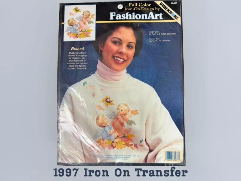 The image is a 1997 Iron On Transfer package featuring a smiling woman with a white sweater adorned with angel designs.