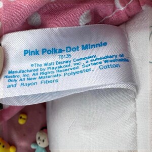 a close-up of a label on a pink fabric, with a small amount of text printed on it.