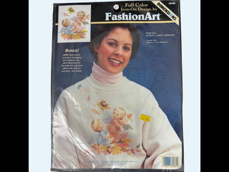 The image is a package for Iron-On Design by FashionArt, featuring a smiling woman with a white sweater adorned with a design of cherubs and leaves.