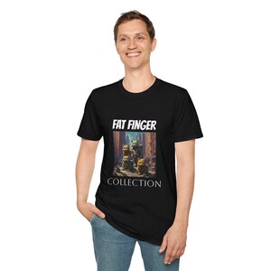 Puede incluir: Camiseta negra con el texto blanco "FAT FINGER COLLECTION". La camiseta presenta un gráfico de tres criaturas de dibujos animados en un entorno urbano. La camiseta está hecha de un material suave.