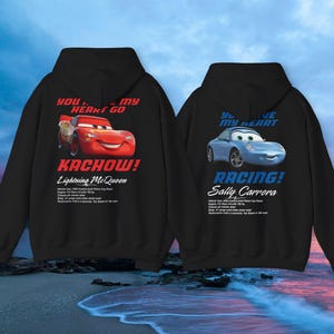 May include: Two black hoodies with Cars movie graphics. One features Lightning McQueen with "Kachow!" and "You stole my heart go" text. The other displays Sally Carrera with "Racing!" and "You stole my heart" text.