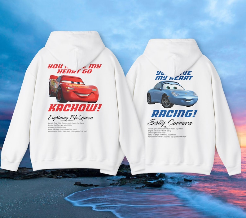 May include: Two white hoodies featuring cartoon car graphics. One displays a red car with "KACHOW!" and "Lightning McQueen" text. The other shows a blue car with "RACING!" and "Sally Carrera" text. Both have text that reads "YOU... MY HEART GO" and "YOU... MY HEART".