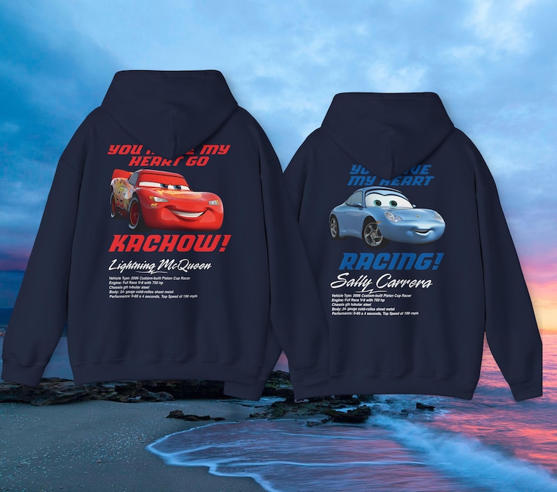 May include: Two navy blue hooded sweatshirts featuring characters from the movie Cars. One displays Lightning McQueen with the text "Kachow!" and the other features Sally Carrera with the text "Racing!"