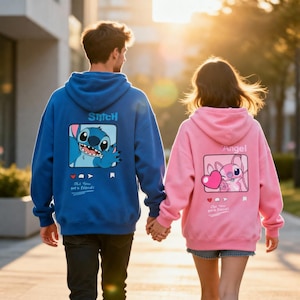 Puede incluir: Dos personas con sudaderas con capucha a juego, una azul y otra rosa, caminando al aire libre. La sudadera azul presenta un gráfico de Stitch, mientras que la sudadera rosa tiene un gráfico de Angel. Ambas tienen el texto "Oh! You got a friend!"