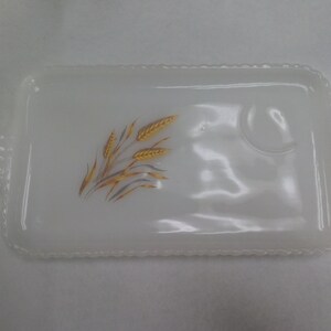 May include: White milk glass serving tray with a raised rim and a small indentation for a cup. The tray features a wheat design in gold and brown.