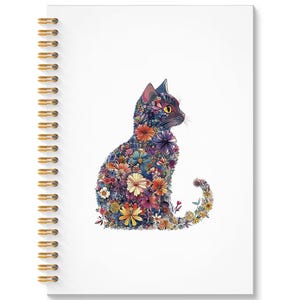 May include: A spiral-bound notebook with a white cover featuring a floral cat design. The cat silhouette is filled with colorful flowers in shades of blue, purple, yellow, and red. The spiral binding is gold.