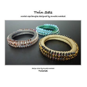 Op de afbeelding: Drie gehaakte touwarmbanden in tinten grijs, teal en goud. De armbanden zijn versierd met kralen en ontworpen door annette mackrel. De tekst "Twin Sets" en "Tutorial" zijn ook zichtbaar.
