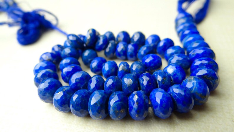 Pu&ograve; includere: Un filo di perline sfaccettate di lapislazzuli blu intenso. Le perline sono di forma ovale e hanno una superficie lucida e riflettente. Il filo &egrave; di colore blu abbinato. Le perline hanno un diametro di circa 0,8 cm.