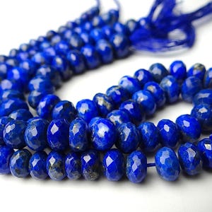 Pu&ograve; includere: Una collana di perline sfaccettate di lapislazzuli blu intenso. Le perline sono infilate insieme, formando una collana o un braccialetto. Le perline hanno una superficie lucida e riflettente, e l'effetto complessivo &egrave; di colore e consistenza ricchi.