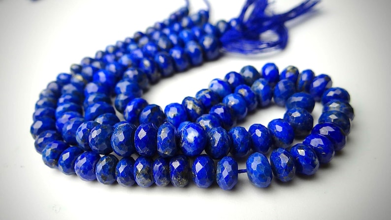 Pu&ograve; includere: Una collana di perline sfaccettate di lapislazzuli blu intenso. Le perline sono infilate insieme, formando una collana o un braccialetto. Le perline hanno una superficie lucida e riflettente, e l'effetto complessivo &egrave; di colore e consistenza ricchi.