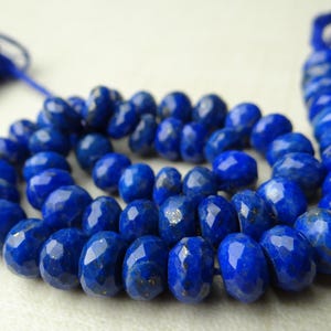 Pu&ograve; includere: Una collana di perline sfaccettate di lapislazzuli blu intenso. Le perline ovali sono infilate insieme, con un nappa blu scuro a ciascuna estremit&agrave;. Le perline hanno una superficie lucida e sono disposte a spirale.