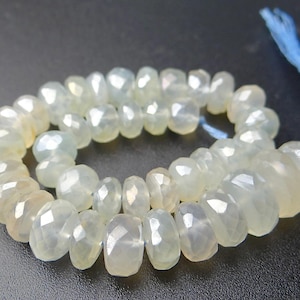 K&ouml;nnte beinhalten: Eine Kette aus facettierten, hellgelb-gr&uuml;nen Edelsteinperlen. Die Perlen sind mit einem blauen Faden aufgef&auml;delt und bilden eine Komponente f&uuml;r eine Halskette oder ein Armband. Die Perlen haben eine durchscheinende Qualit&auml;t und eine polierte Oberfl&auml;che.