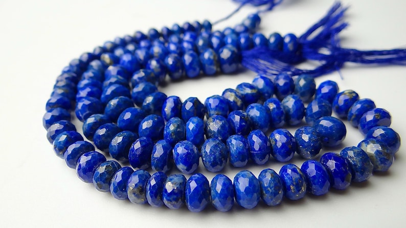 Pu&ograve; includere: Un filo di perline sfaccettate di lapislazzuli blu intenso. Le perline ovali sono infilate, con un nappa all'estremit&agrave;. Le perline misurano circa 0,8 cm.