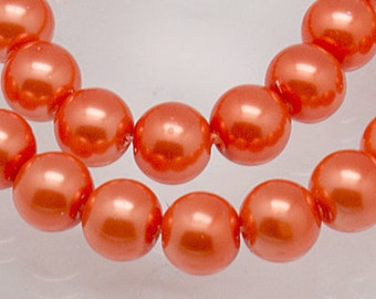 May include: A strand of round, glossy, coral-orange beads arranged in two curved rows. Each bead features a smooth, reflective surface with a consistent spherical shape and a uniform, vibrant orange color throughout the entire collection.