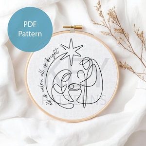 Könnte beinhalten: Ein Stickrahmen mit weißem Stoff und einer minimalistischen schwarzen Strichzeichnung der Geburt Christi, einem Stern und den Worten "all is calm, all is bright". Ein blauer Kreis mit "PDF Pattern" befindet sich oben links.