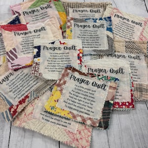 May include: A collection of small, colorful patchwork prayer quilts with a poem printed on each one. The poem reads: "I'm a little prayer quilt to hold in your hand. For when trouble arises, the things you did not plan, hold me tight in your fist. If it helps calm your fears, and don't be afraid to use me to wipe away your tears."