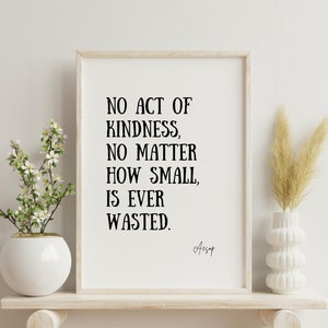 May include: A framed print with a white background and black text that reads "NO ACT OF KINDNESS, NO MATTER HOW SMALL, IS EVER WASTED." The text is attributed to Aesop.