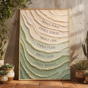 May include: Textured wall art in a gold frame. The artwork features layered, wave-like patterns in shades of green, beige, and gold. The text reads "INHALE PEACE. EXHALE STRESS. INHALE LOVE. EXHALE FEARS. INHALE CALM. EXHALE WORRIES."