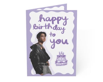 May include: A folded greeting card with a light purple border and a white center. The text "happy birthday to you" is written in purple script. A photograph of a person in a black leather jacket and a purple line drawing of a cake are included.