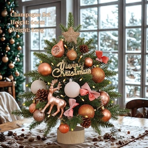 Pode incluir: Uma pequena árvore de Natal, com 60 cm de altura, adornada com enfeites cor de champanhe, laços e uma estrela. Inclui um letreiro "Merry Christmas" e uma figura de rena. A base é um cilindro de madeira e a árvore pesa 820g.