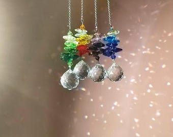 May include: Four crystal suncatchers with rainbow coloured crystal beads hanging from silver chains. Each suncatcher has a clear crystal ball at the bottom.